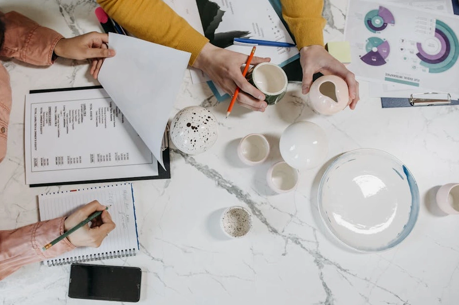 Osoba zapisující si poznámky do zápisníku během obchodního jednání